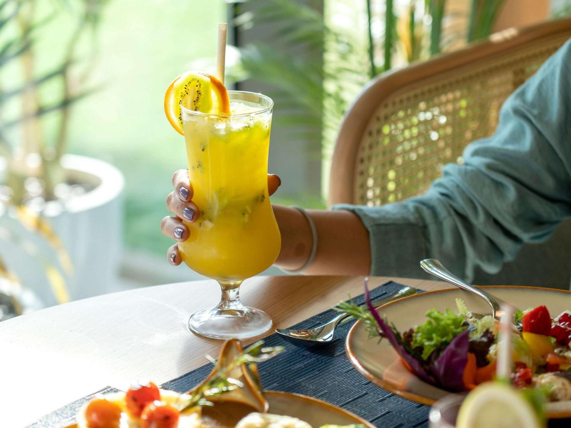 Swissotel Living Dżedda Zewnętrze zdjęcie A woman holding a glass of juice